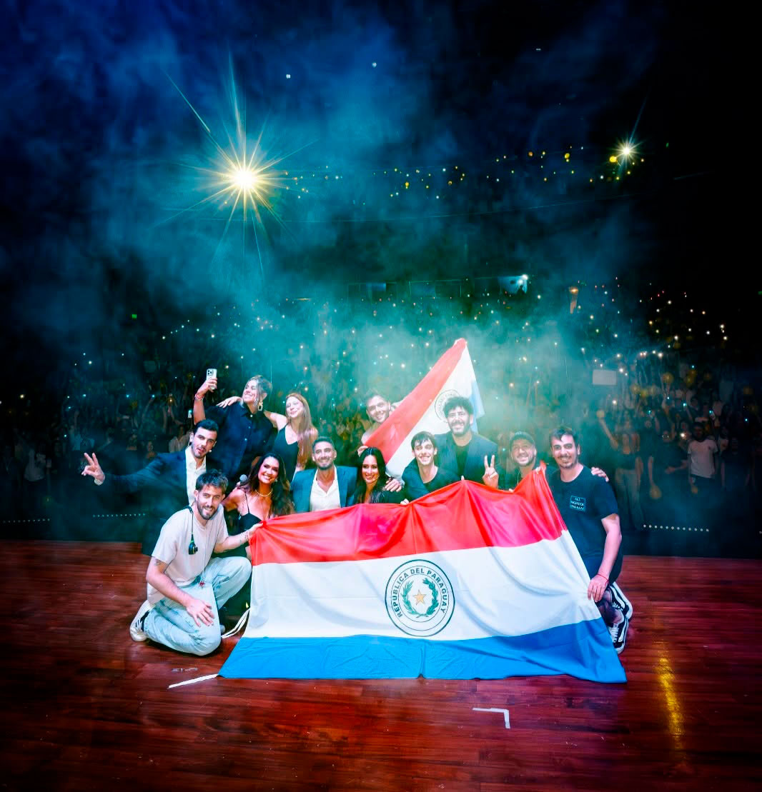 El equipo de Nadie Dice Nada en el escenario con la bandera paraguaya